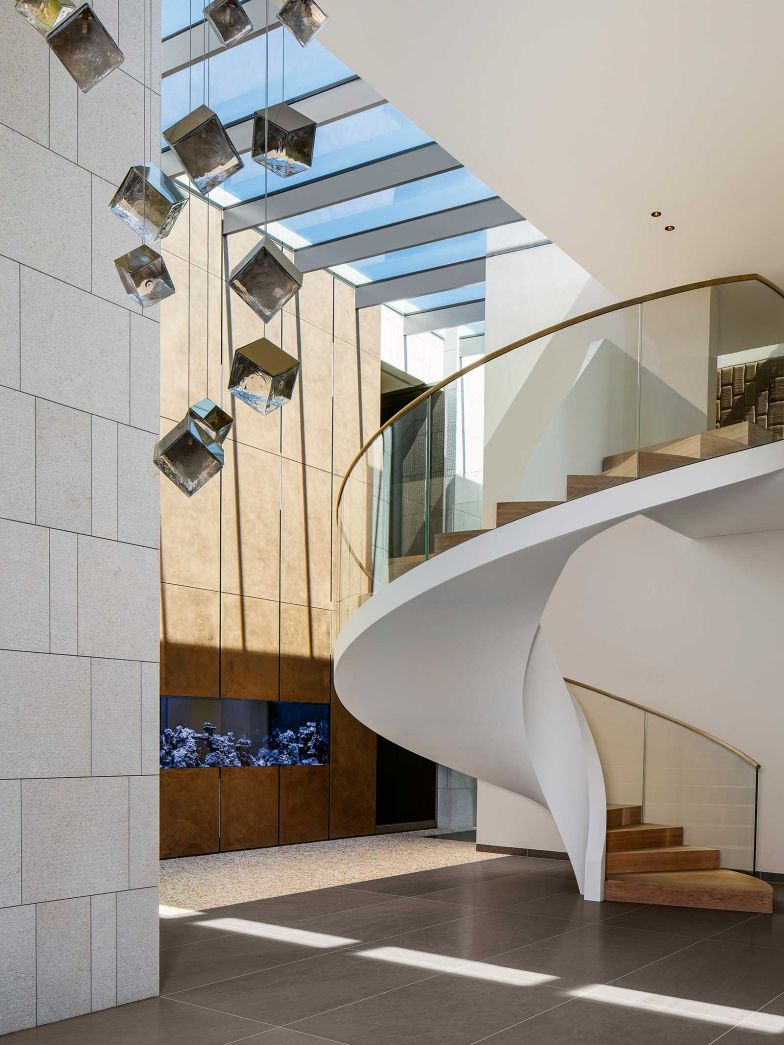 Elegantes Meisterwerk: Eine aussergewöhliche Wendeltreppe führt vom Atrium ins Obergeschoss. In die Rückwand links ist ein Aquarium eingelassen.