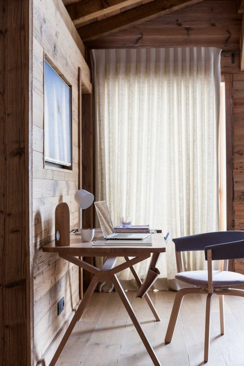 Homeoffice im Ferienhaus: Im Schlafzimmer der Eigentümer gibt es einen kleinen Arbeitsplatz mit Schreibtisch «Bolsa» von Wewood und Stuhl «Wood Bikini» von Werner Aisslinger für Moroso.