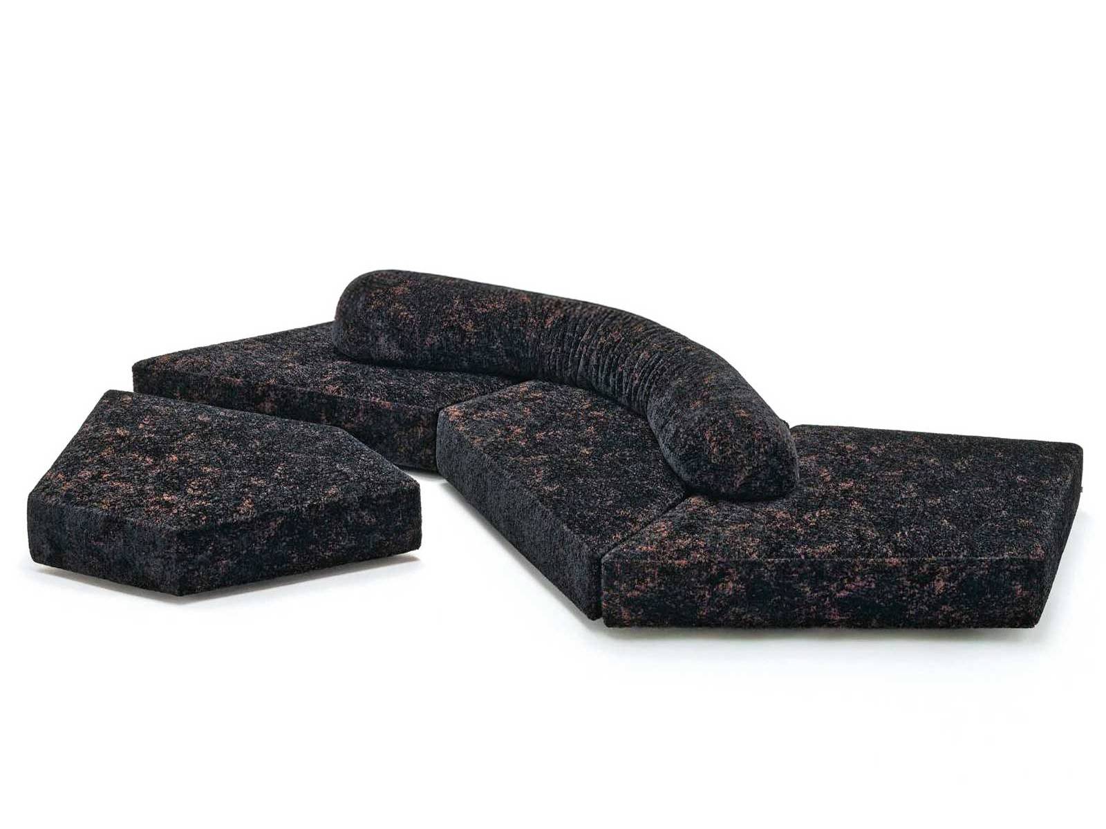 Wie geschliffener Obsidian liegt das Sofa «On the Rocks» im Raum. Der neue Stoff «Gems» bringt Glanz, Tiefe und eine fast mineralische Präsenz in die schwarze Fläche. EDRA.